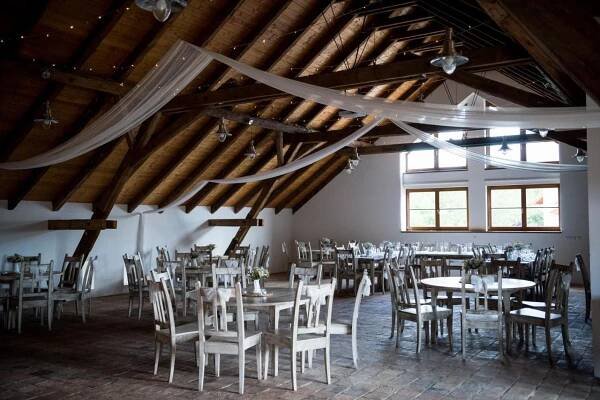 a room full of tables and chairs in a building at Dvůr Perlová voda in Budyně nad Ohří