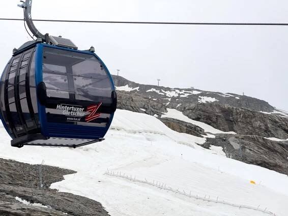 A Hintertux Glacier cable car glides over a glacier high up a mountain in the Zillertal Valley, Austria.