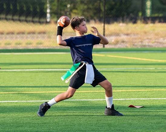 Youth flag football quarterback throwing football