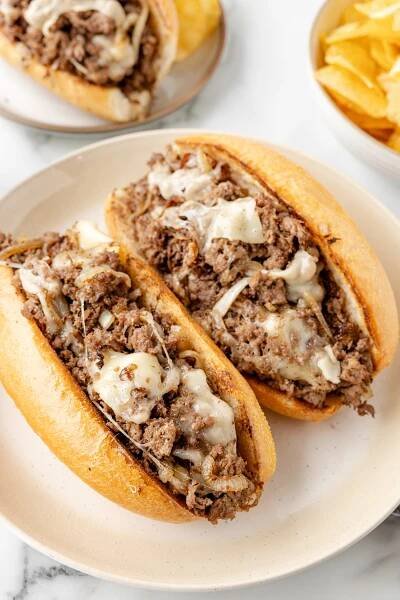 Blackstone Philly Cheesesteaks on a white plate with carmalized onoins and provolone cheese.