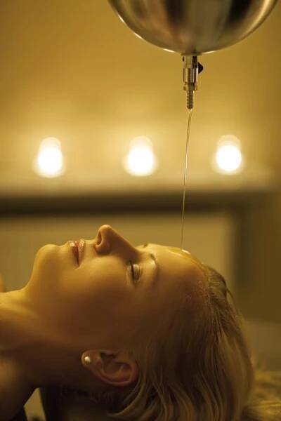 a young woman is lying down with a stream of water from a balloon at Malinowy Dwór Hotel Medical SPA in Świeradów-Zdrój