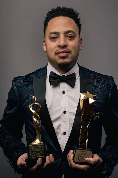man holding both of his awards 