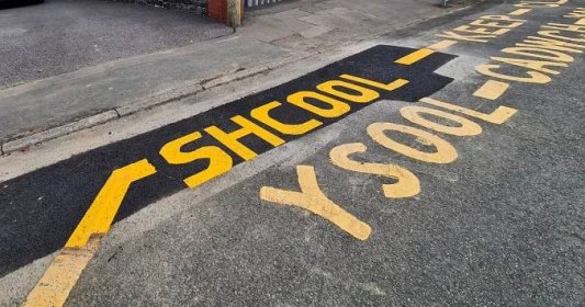 Road workers spell 'school' incorrectly in English and Welsh outside a primary