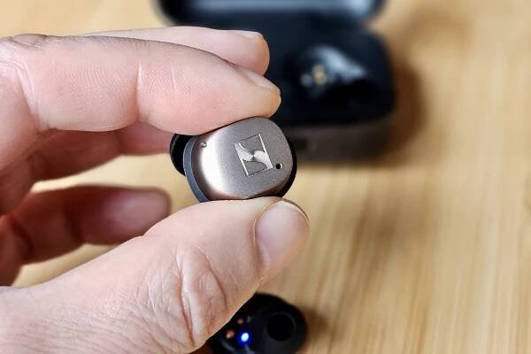 Left Sennheiser Momentum True Wireless 4 held by hand.