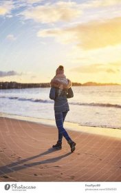 Young woman walking on the beach with winter clothing at sunset in Vigo - a Royalty Free Stock Photo from Photocase