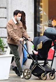 the two walking with their daughter in a stroller
