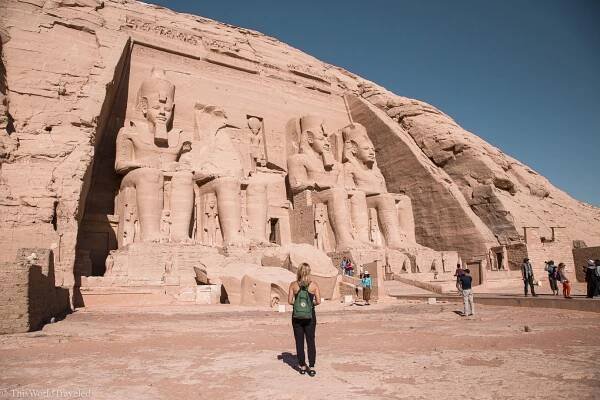 Girl standing in front of the statues at Abu Simbel in Aswan, Egypt