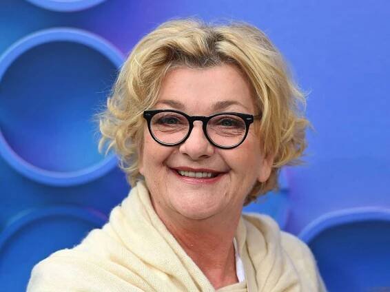 Wir sehen Saskia Vester mit Brille vor blauem Hintergrund