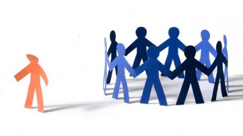 Circle of paper cut-out figures holding hands and one cut-out figure standing apart