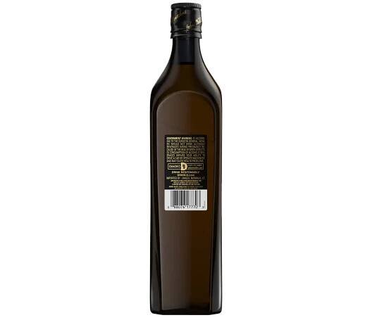 A brown glass bottle with a black label and gold accents, viewed from the back. The label has text and symbols, and a barcode is visible at the bottom. The bottle is sealed with a black cap.