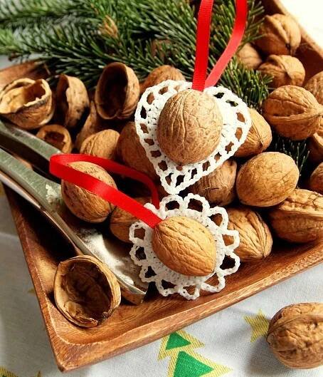 some nuts are sitting on a wooden tray with red ribbon and scissors next to them