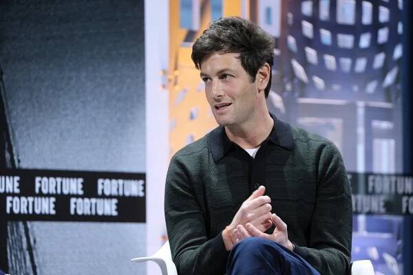 Joshua Kushner, the founder of Thrive Capital, looking to his right, wearing a dark shirt and dark blue pants.