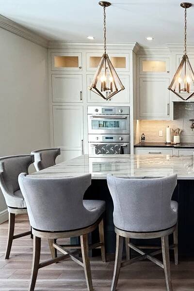 Sherwin Williams Pearly White painted kitchen cabinets, wood floor, quartzite countertop, Benjamin Moore French Beret, dark blue island