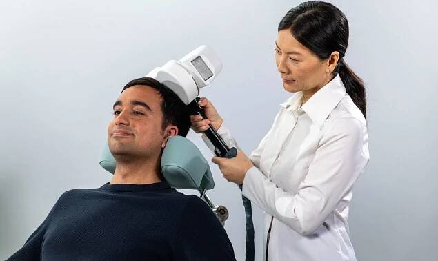 A practitioner places a TMS coil for TMS therapy. 