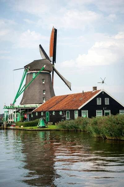 Charming Dutch windmill by water in Zaanse Schans, Netherlands.