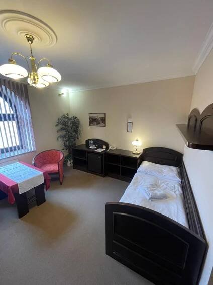 a bedroom with a bed and a desk and a chair at Hotel Bravo in Česká Třebová