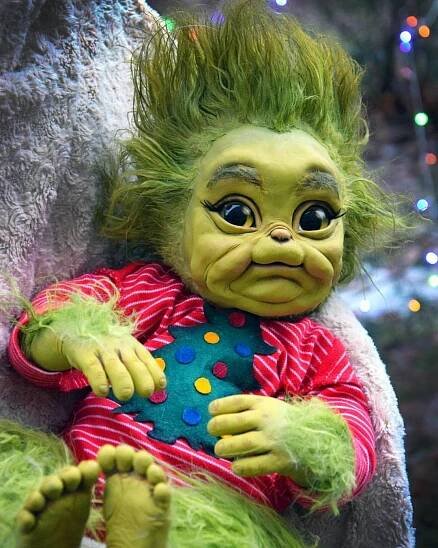 Baby Grinch In Onesies Christmas Attire Wallpaper