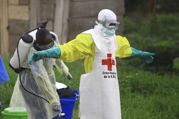 A health worker sprays disinfectant on his colleague after working at an Ebola treatment center in Beni, eastern Congo.