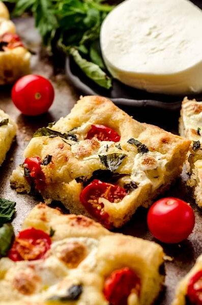Caprese focaccia slice on a baking sheet.