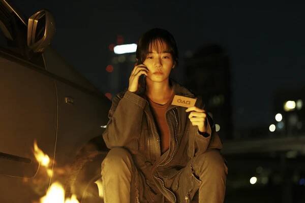 Kang No-eul, from Squid Game season 2, on a phone call, holding a card with symbols.