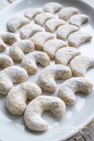 powdered sugar donuts are on a white platter and ready to be eaten
