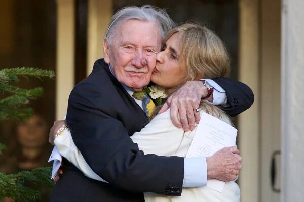 Leslie Phillips and Zara Carr embracing after their wedding.