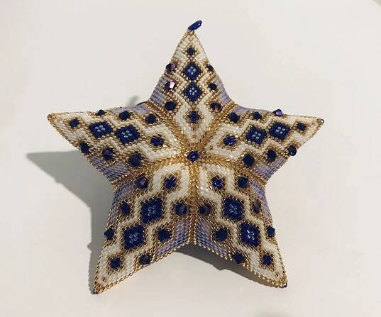 a beaded star ornament on a white surface