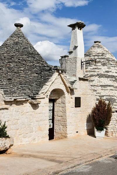 bezplatná Tradiční kamenné domy trulli pod jasnou modrou oblohou v Alberobello, Itálie. Základová fotografie