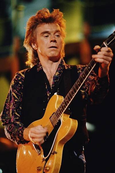 Dave Edmunds playing electric guitar during a concert.