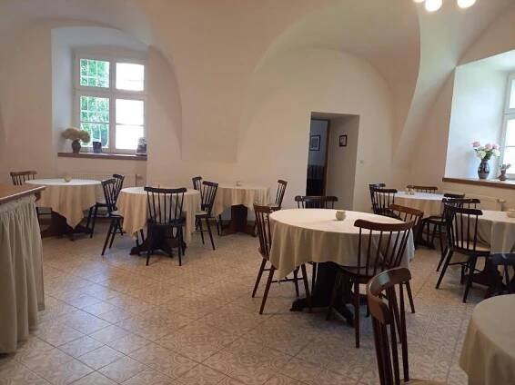 a dining room with tables and chairs and a room filled with tables and chairsktop at Penzion Zámek Rozsochatec in Rozsochatec