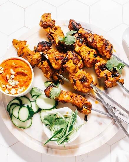 Thai Satay skewers with peanut sauce on a plate.