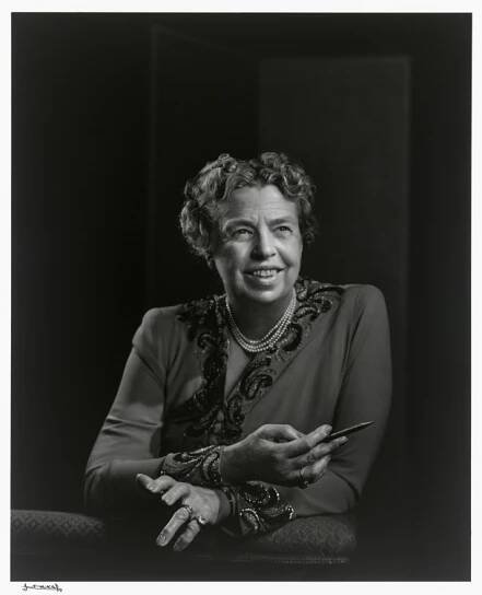 an old black and white photo of a woman holding something in her hands with both hands