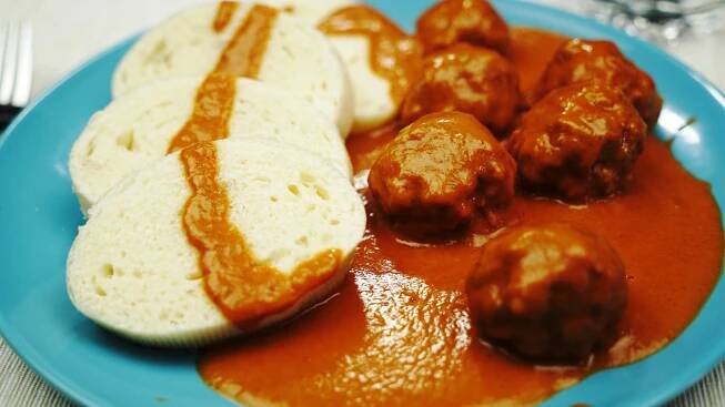 a blue plate topped with meatballs and bread