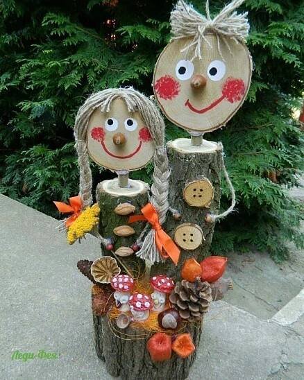 two wooden faces are sitting on top of a tree stump with mushrooms and other items
