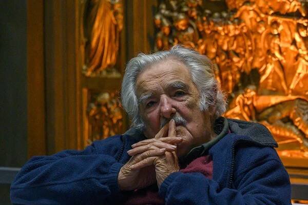 José Mujica poses with his hands on his chin.