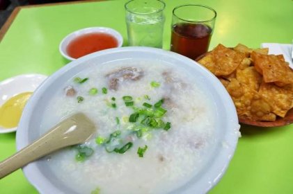 A bowl of congee set against a neon green background at Wo Hop.