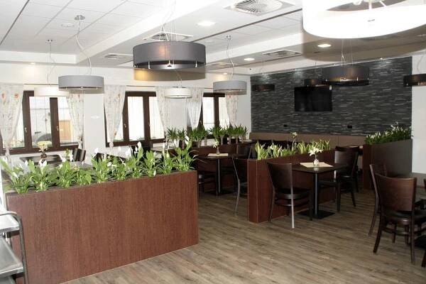 a restaurant with tables and chairs and plants at Penzion Aladdin in Teplice