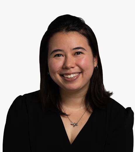 Megan Lewin-Smith, an Asian woman with dark hair, a smile, and a very cool bird necklace.