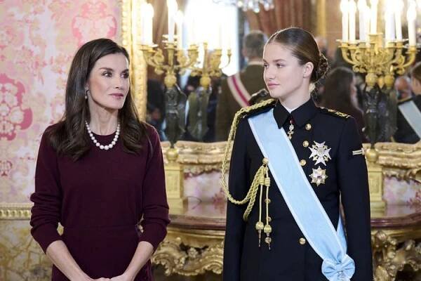 Queen Letizia in a burgundy dress with Princess Leonor in her Navy dress uniform