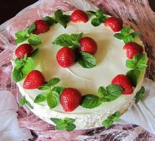 a cake decorated with strawberries and green leaves