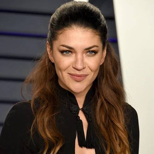 Jessica Szohr wears a long, wavy half-up hairstyle at the 2019 Vanity Fair Oscar Party in Beverly Hills, California 