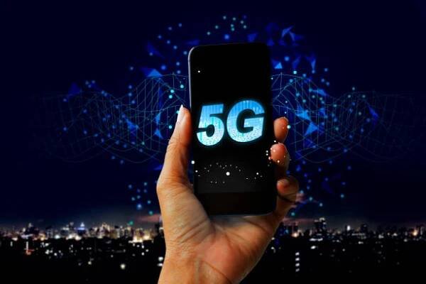 Digitální hologram sítě 5G a internet věcí na pozadí města - Ruční držení mobilního telefonu koncept budoucí technologie 5G sítě stock fotka