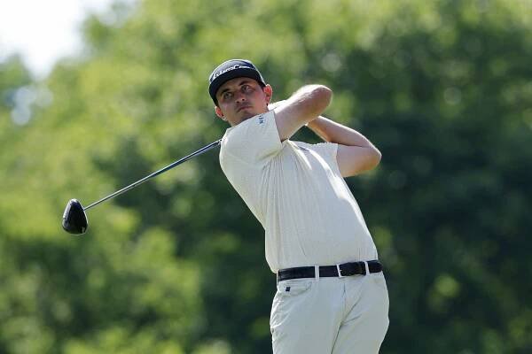 JT Poston hits a tee shot with a driver