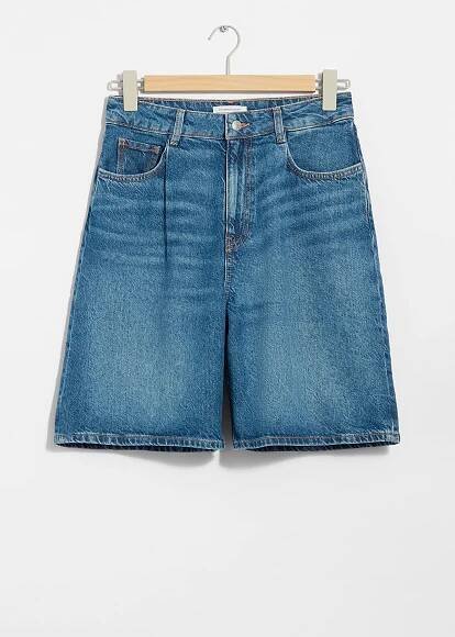 A pair of mid blue relaxed denim shorts on a rack, available for $99