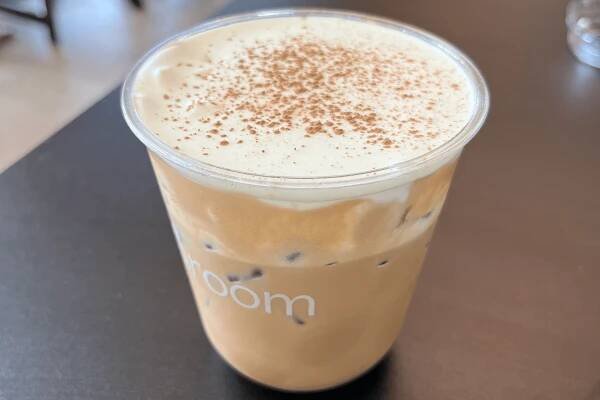 A cup of iced coffee topped with cream
