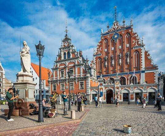 Riga's Town Hall Square with musicians performing and the House of the Blackheads in the background.
