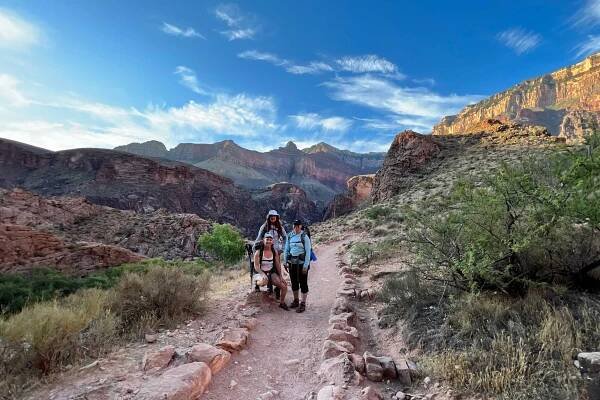 Day Hikes Home On the Bright Angel Trail below Havasupai Gardens with a blue sky above and Mather Point and O'neil butte and skeleton point off the south kaibab trail in the background. Two nights at the Havasupai garden campground is one of the most popular trips to take with Desert Hiking Company.
