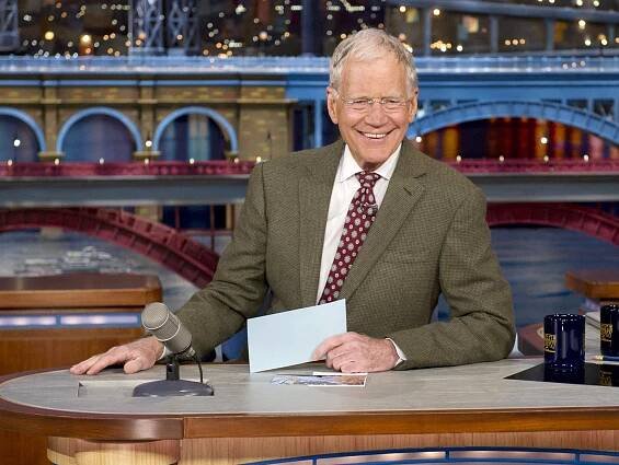 David Letterman holding his cards
