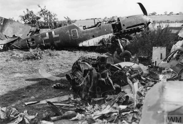 THE REMAINS OF a Messerschmitt Bf 109E-4 - Werk Nummer 5587 - wearing the code 'Yellow 10' from 6. Staffel, Jagdgeschwader 51 in a British scrapyard. Note the holes in the rear fuselage where the unit's badge has been removed and the - apparently - crudely amputated tail of the aircraft which would have been adorned with the Hakenkreuz (Swastika), the yellow segment at the tip of the fin and the three victory markings achieved by the pilot. Image Copyright © IWM. IWM catalogue reference H 4222. Original source https://www.iwm.org.uk/collections/item/object/20522301.