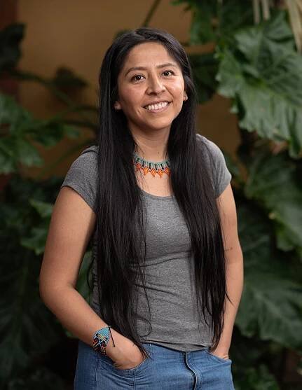 A woman with dark hair smiles at the camera.